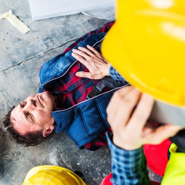 Colleague,Giving,First,Aid,To,Unconscious,Worker,After,Accident,,Calling